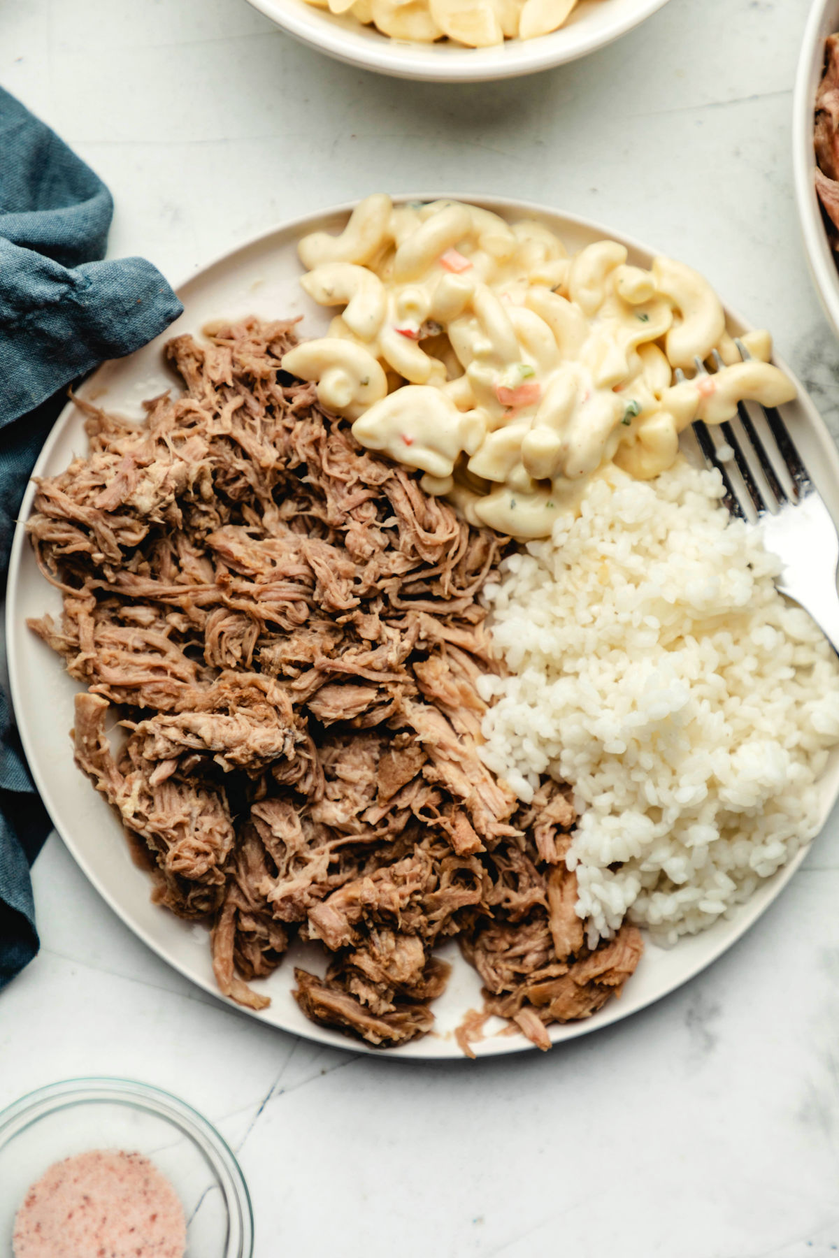 A white plate with Instant Pot kalua pork white rice and macaroni salad on it. 