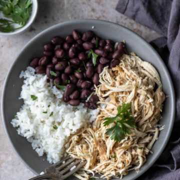 Shredded mojo chicken in a bowl with black beans and rice.