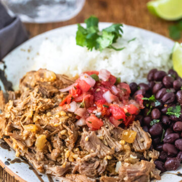 Plate with white rice, black beans, and mojo pork on it.