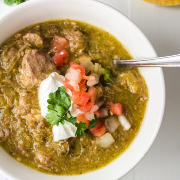 White bowl with pork chile verde in it.