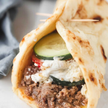 Ground beef gyro on white parchment paper.