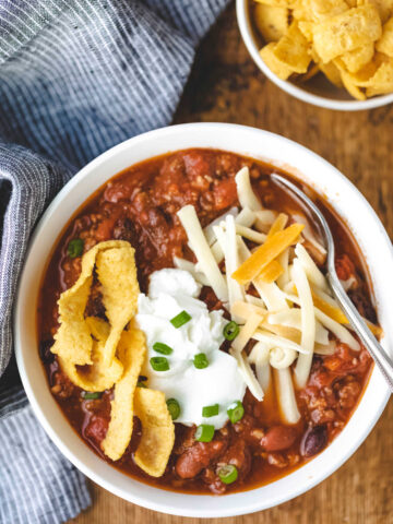 Bowl of chipotle chili topped with cheese and sour cream.