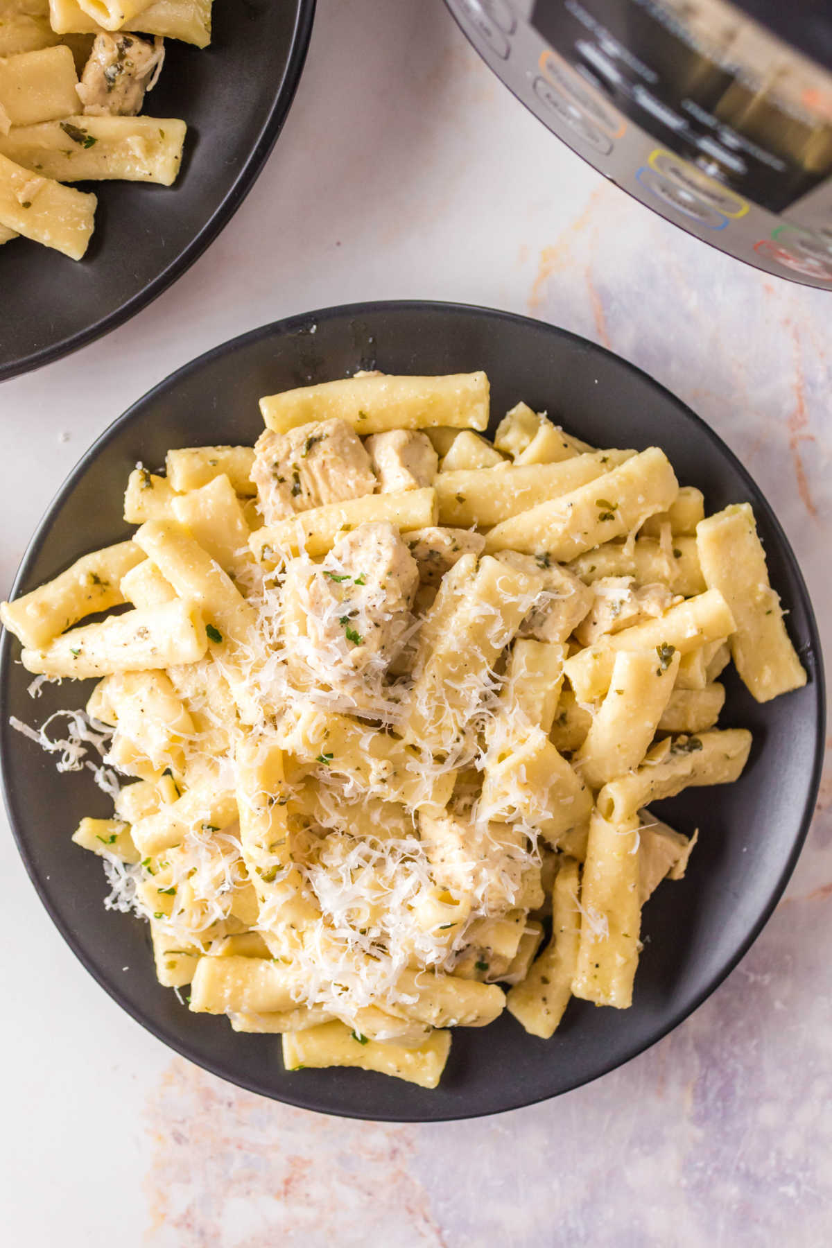 A black plate with Olive Garden chicken pasta on it.