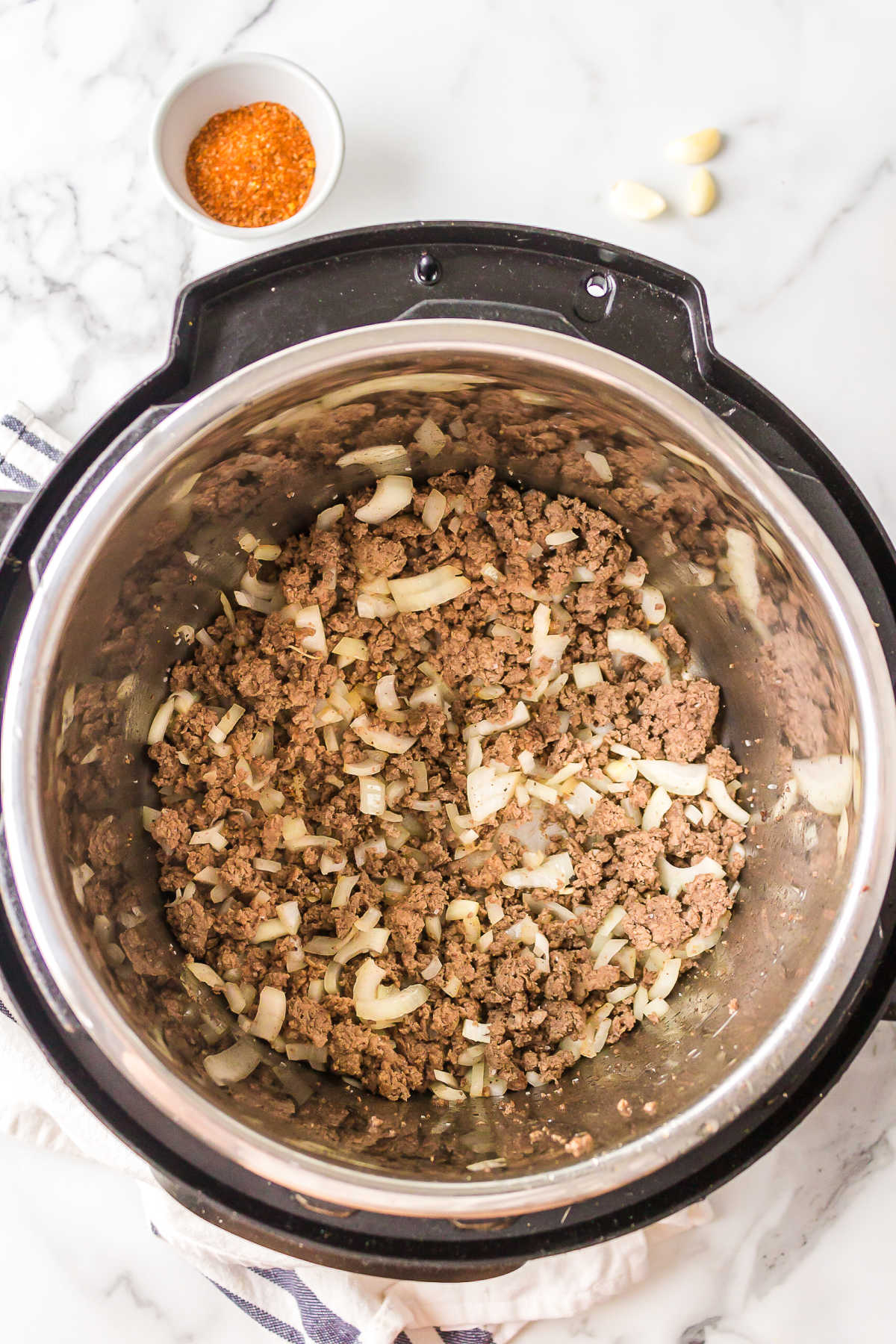 Browned ground beef and onion in an instant pot inner pot. 