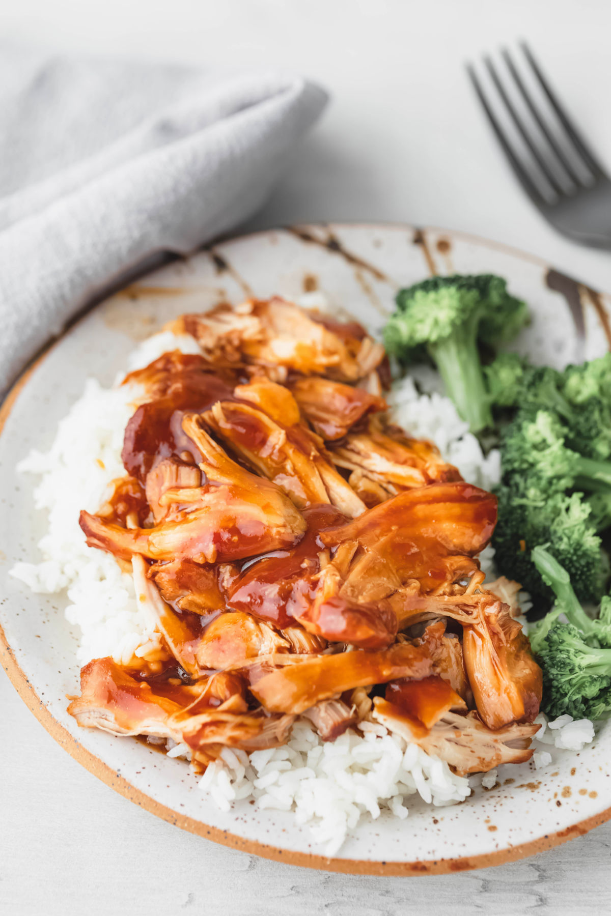Honey bourbon chicken rice and broccoli on a plate. 