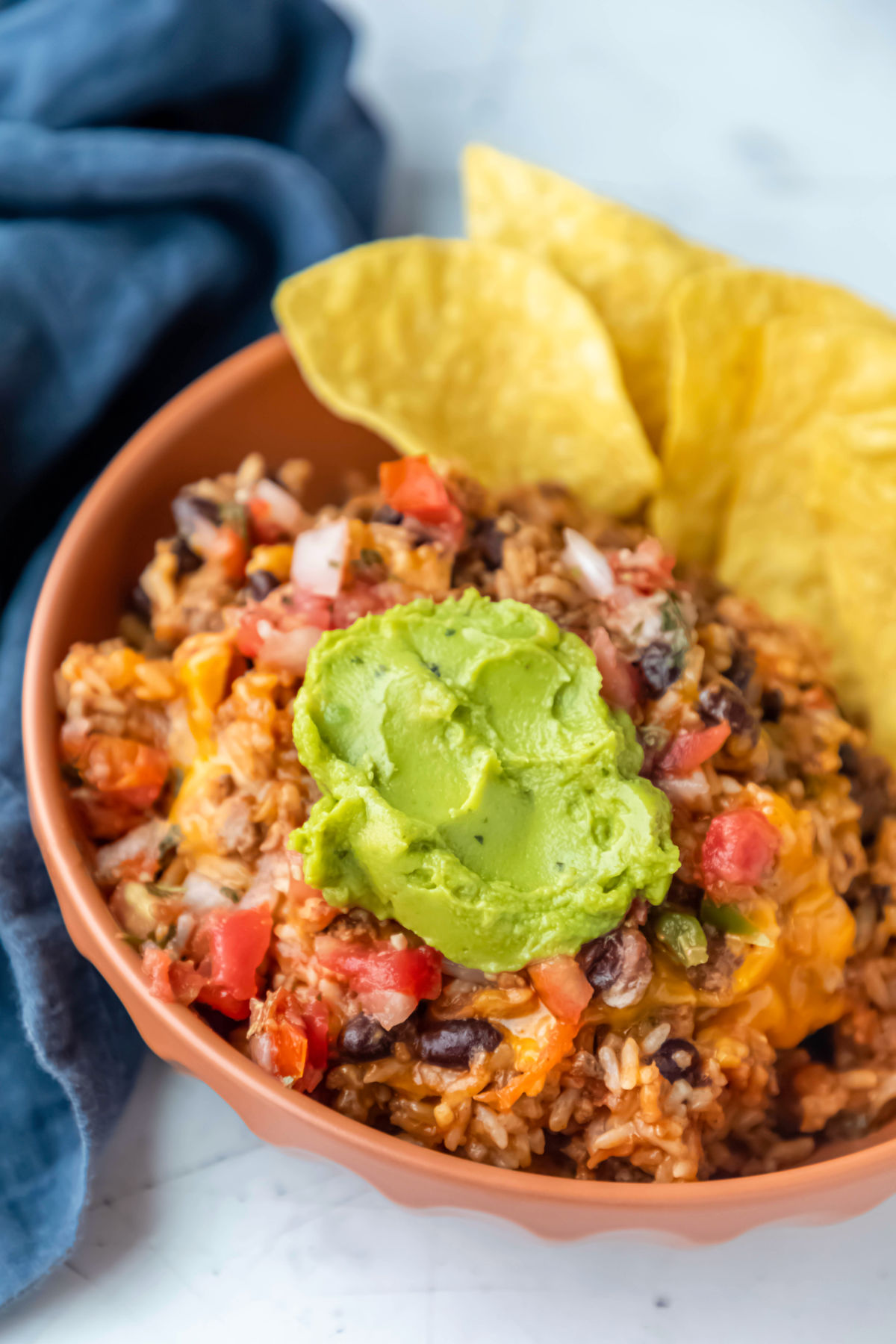 Instant Pot cheesy taco rice in a dish topped with guacamole.