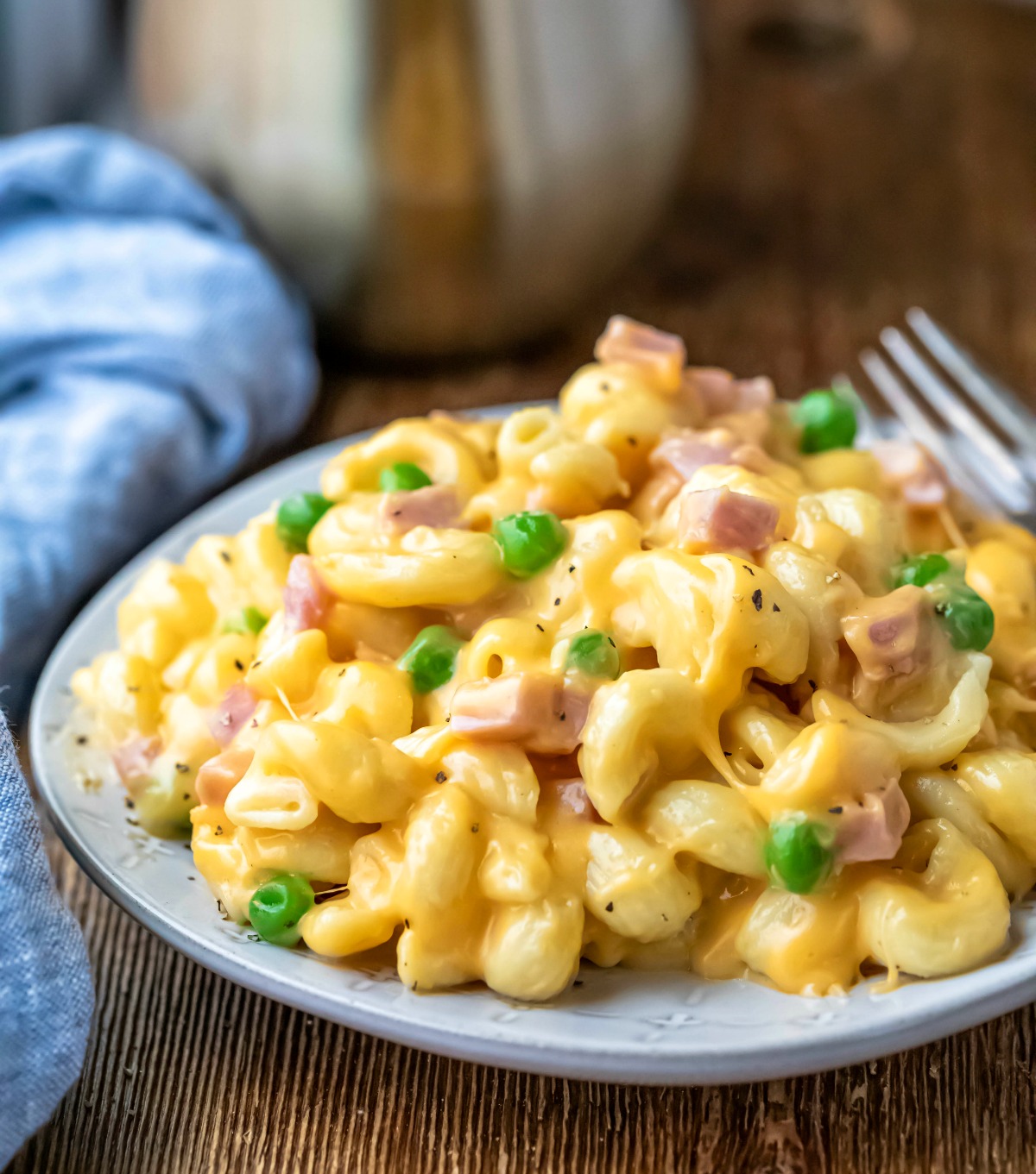 Instant Pot macaroni and cheese with ham and peas on a light blue plate. 