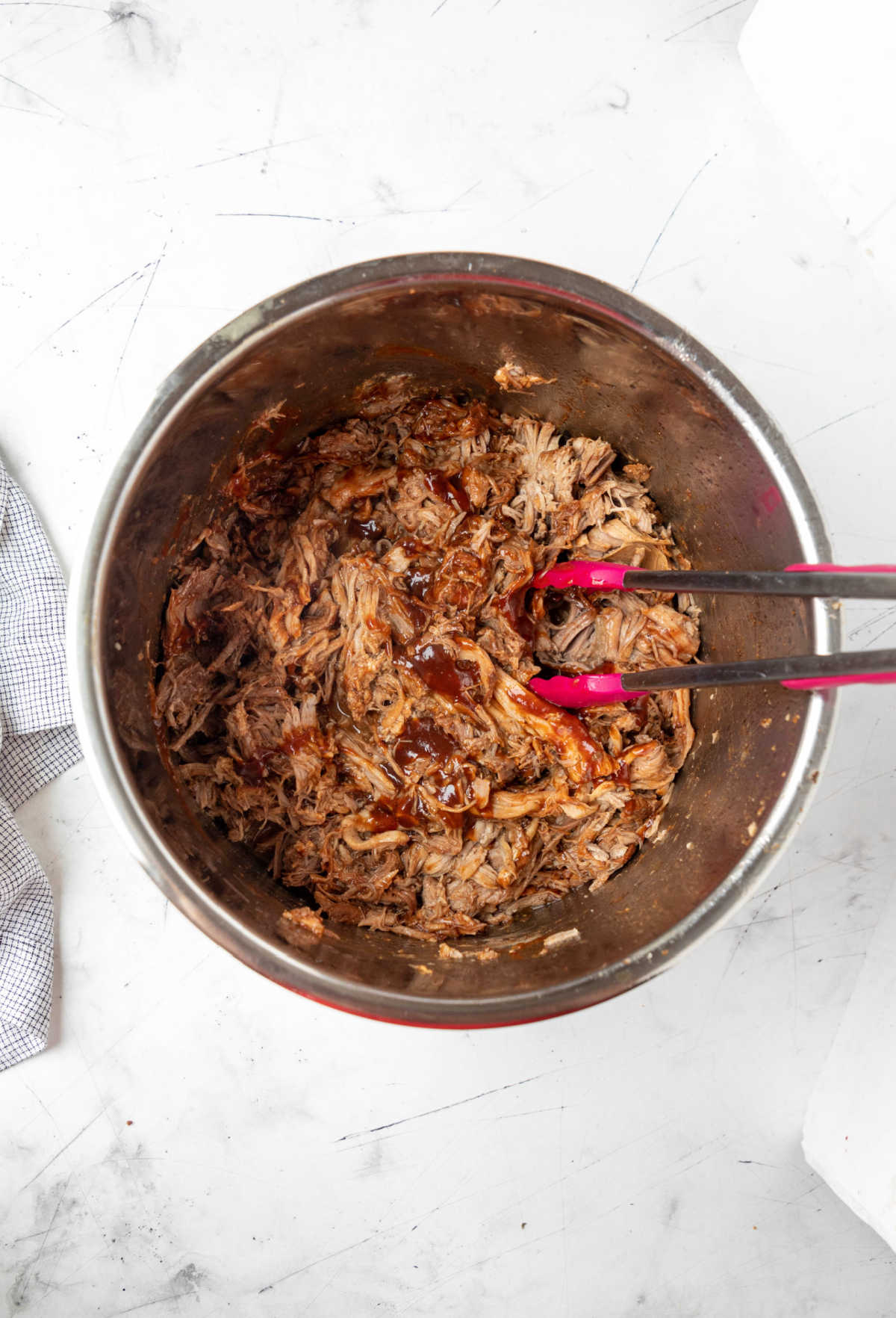 Shredded pulled pork with barbecue sauce in an instant pot inner pot. 