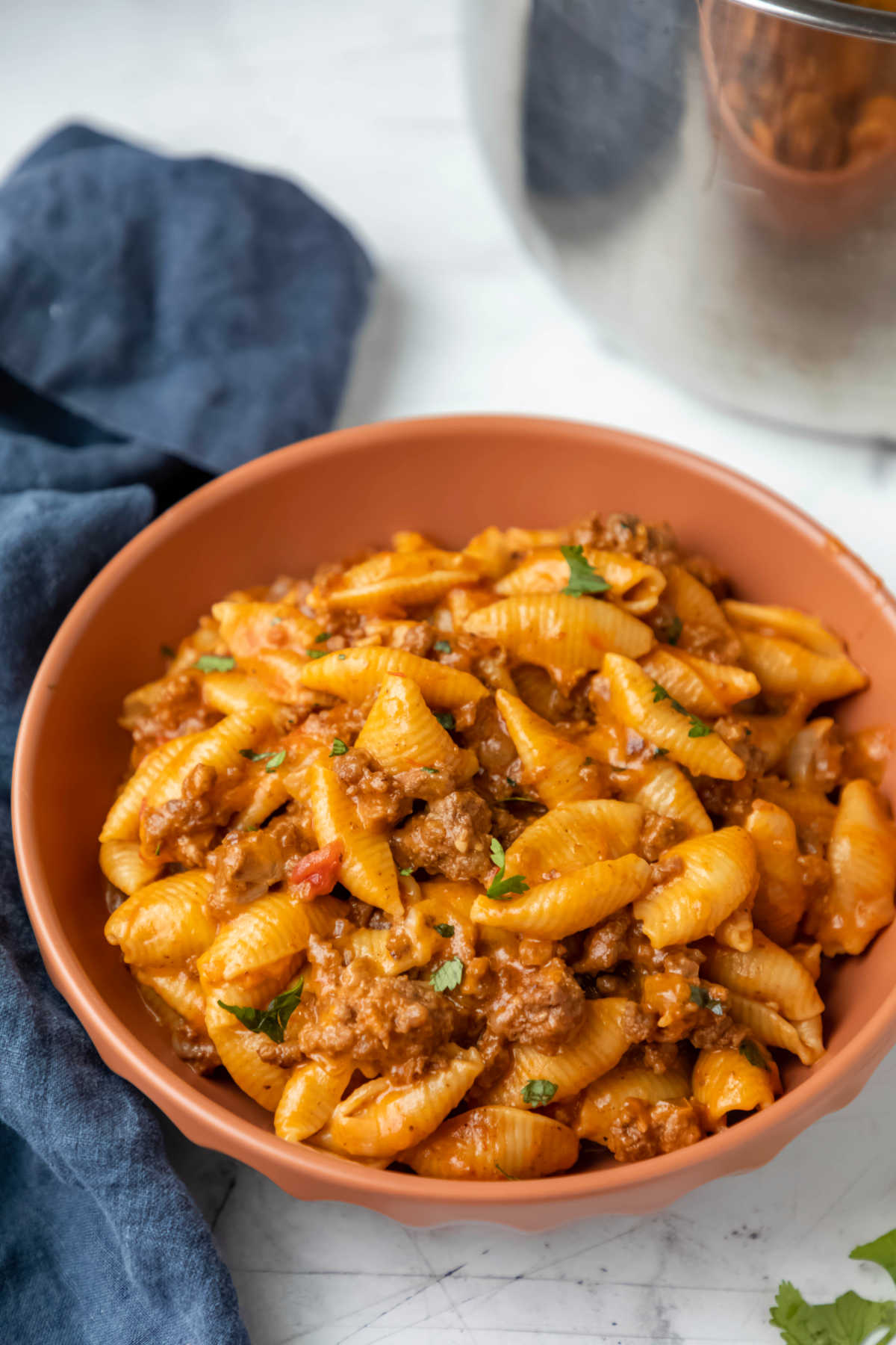 Bowl of instant pot taco pasta next to a blue linen.