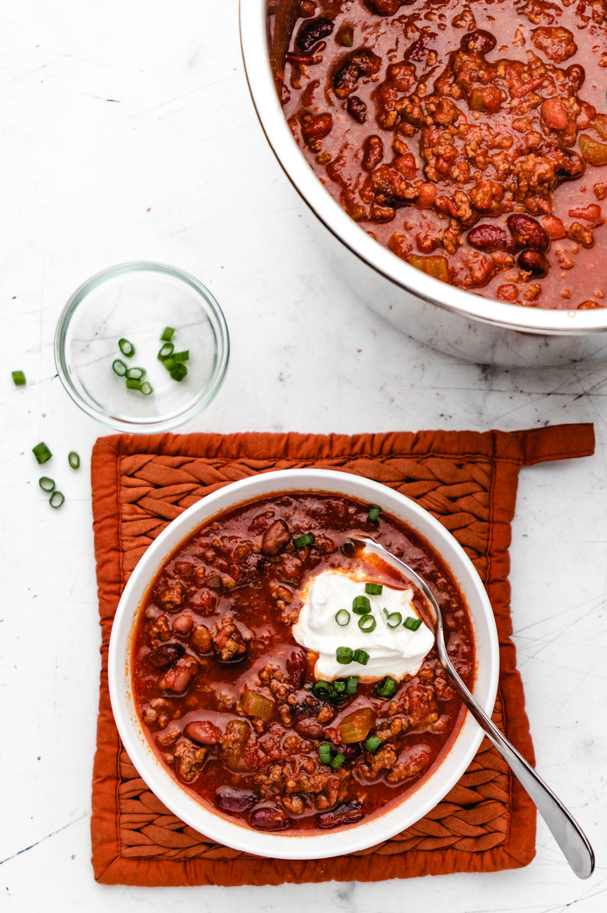 A bowl of Instant Pot Wendy's chili next to a pot of chili.