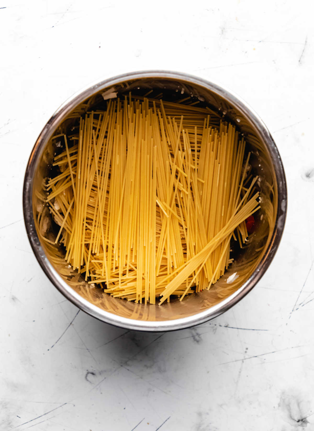 Spaghetti noodles crisscrossed in an instant pot. 
