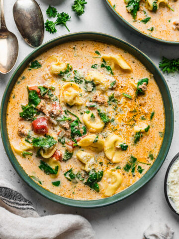 A bowl of Instant Pot creamy tortellini soup in a green bowl.