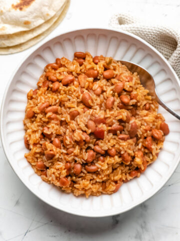 A white plate with Instant Pot Mexican rice and beans with a spoon in it.