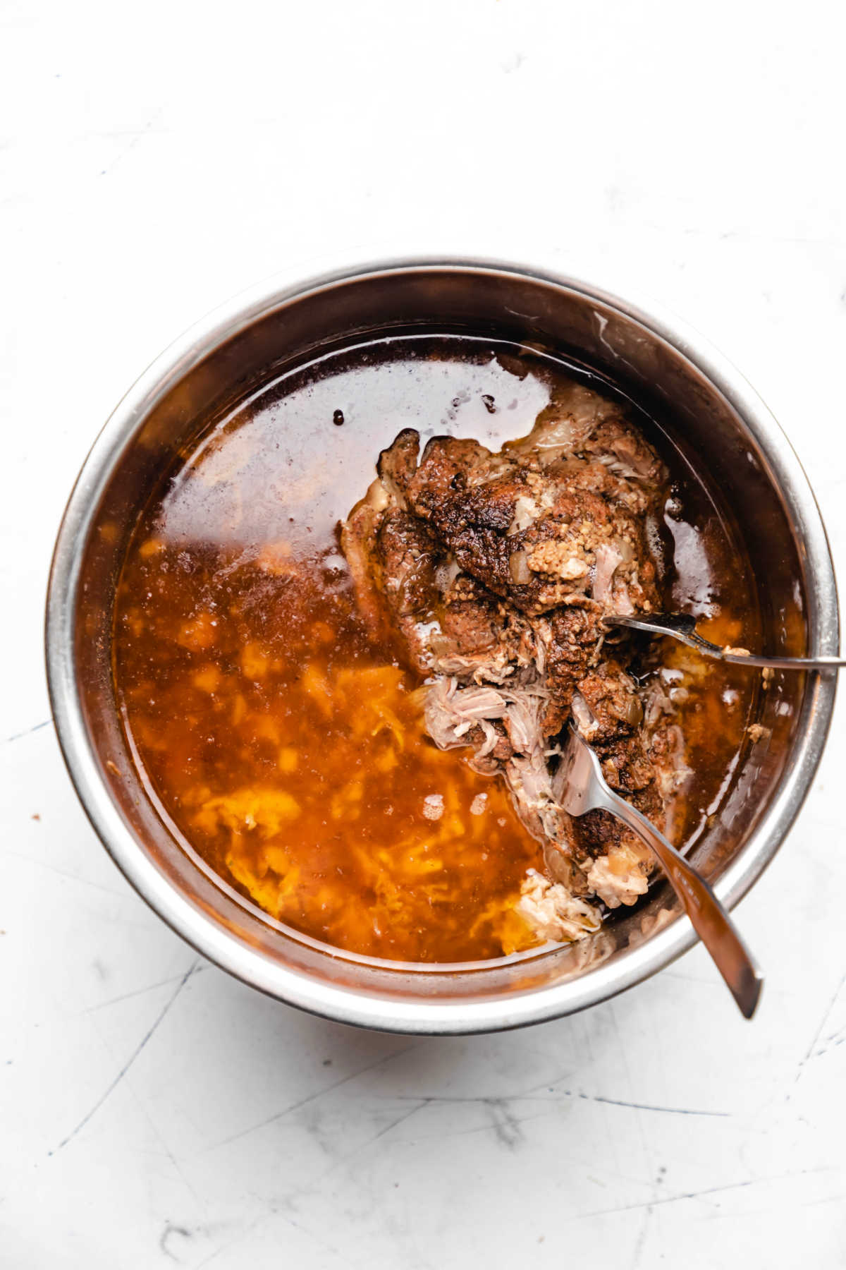 Two forks shredded Mexican pork in an Instant Pot.