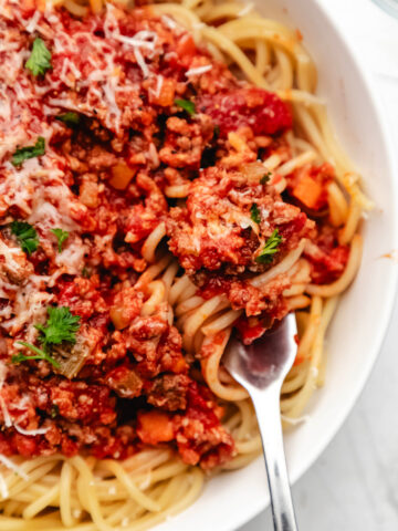 A fork holding a twirl of spaghetti topped with Instant Pot bolognese.