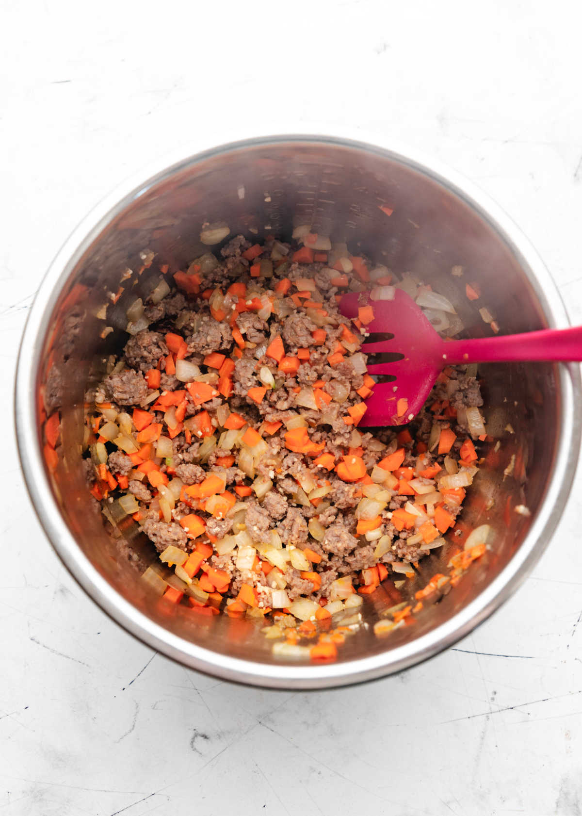 Garlic cooking with Italian sausage and onion and carrot.