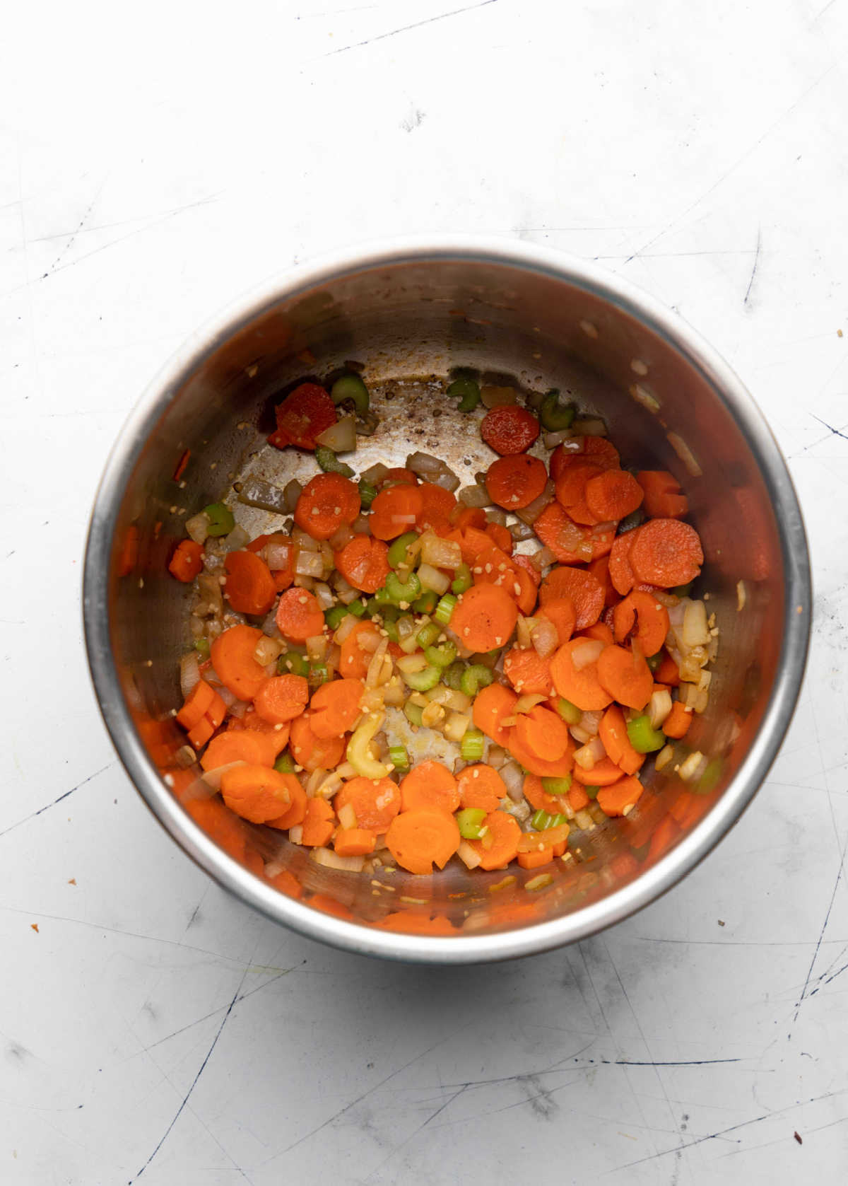 Onions celery and carrot sauteeing in an Instant Pot.