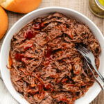 A dish of Instant Pot cola pulled beef with two forks in it.